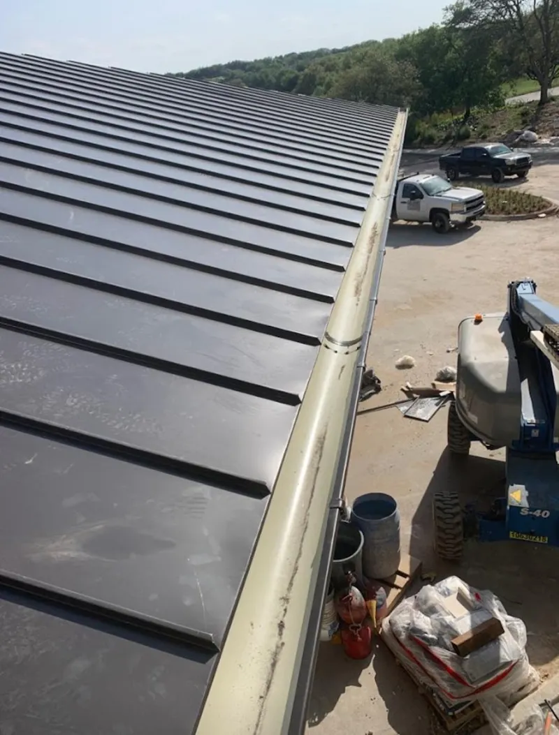 Standing seam panel and gutter detail on a metal roofing jobsite in Latimer